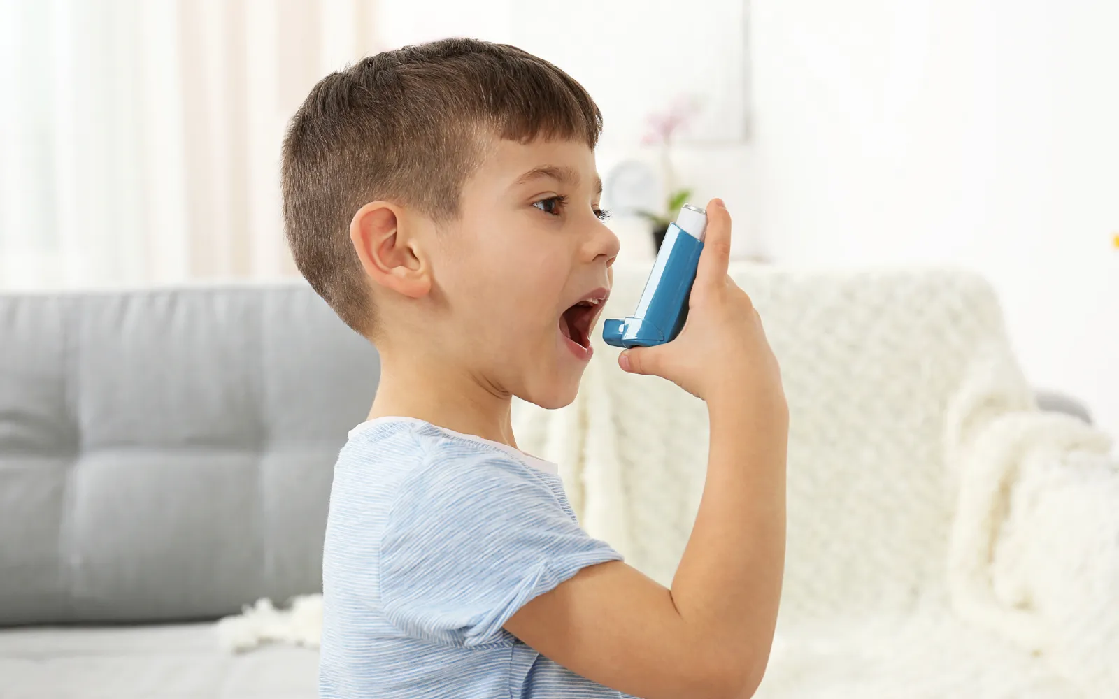 A child with an asthma inhaler, representing one of the most common mold exposure symptoms