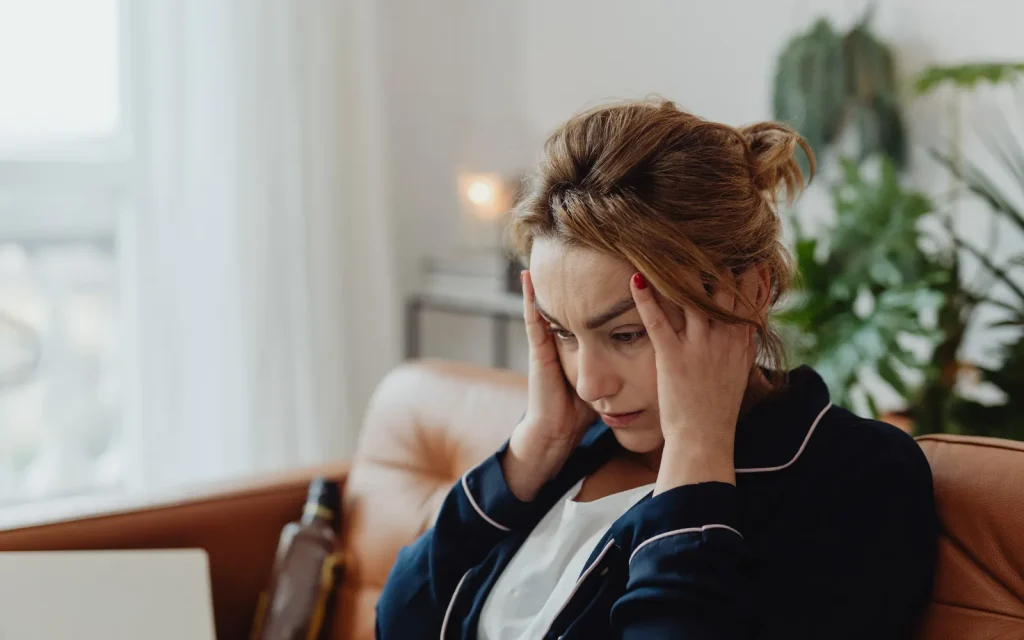 A woman holding her head, representing a mold-caused headache