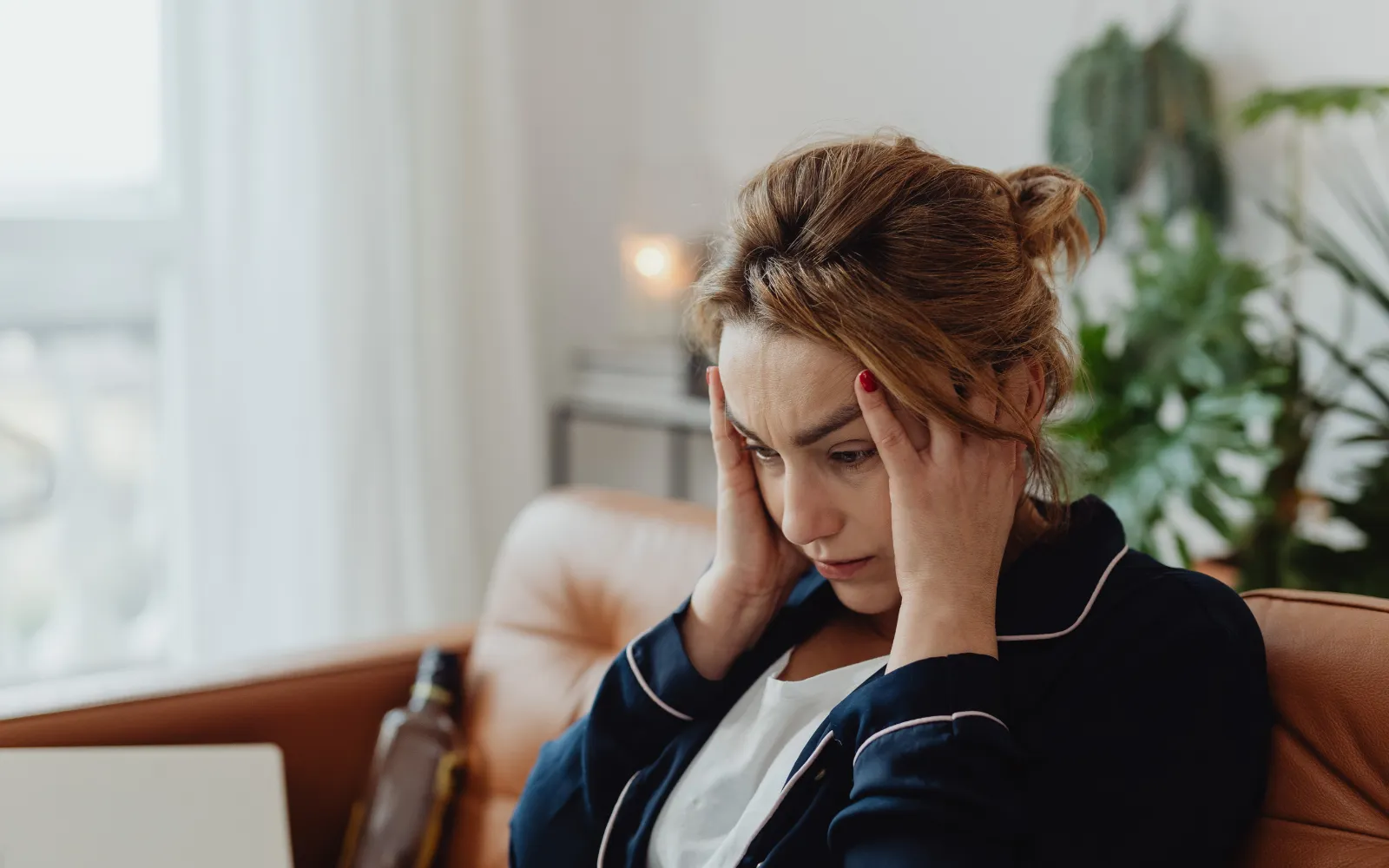 A woman holding her head, representing a mold-caused headache